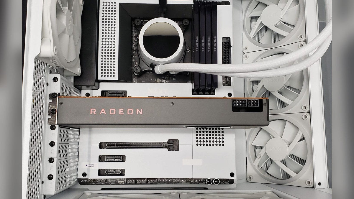 Top-down view of an AMD Radeon graphics card installed in a white PC case with a white AIO cooler and fans