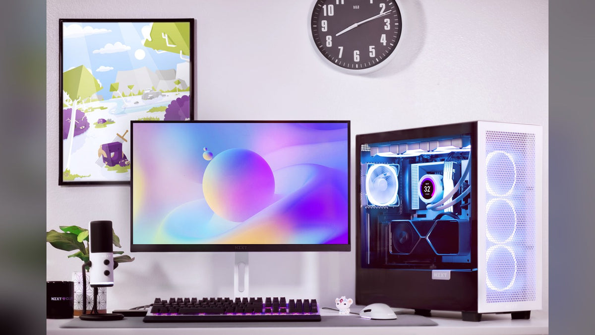 Desk with an NZXT monitor, purple-lit keyboard, white microphone, and an NZXT case with an LCD AIO liquid cooler
