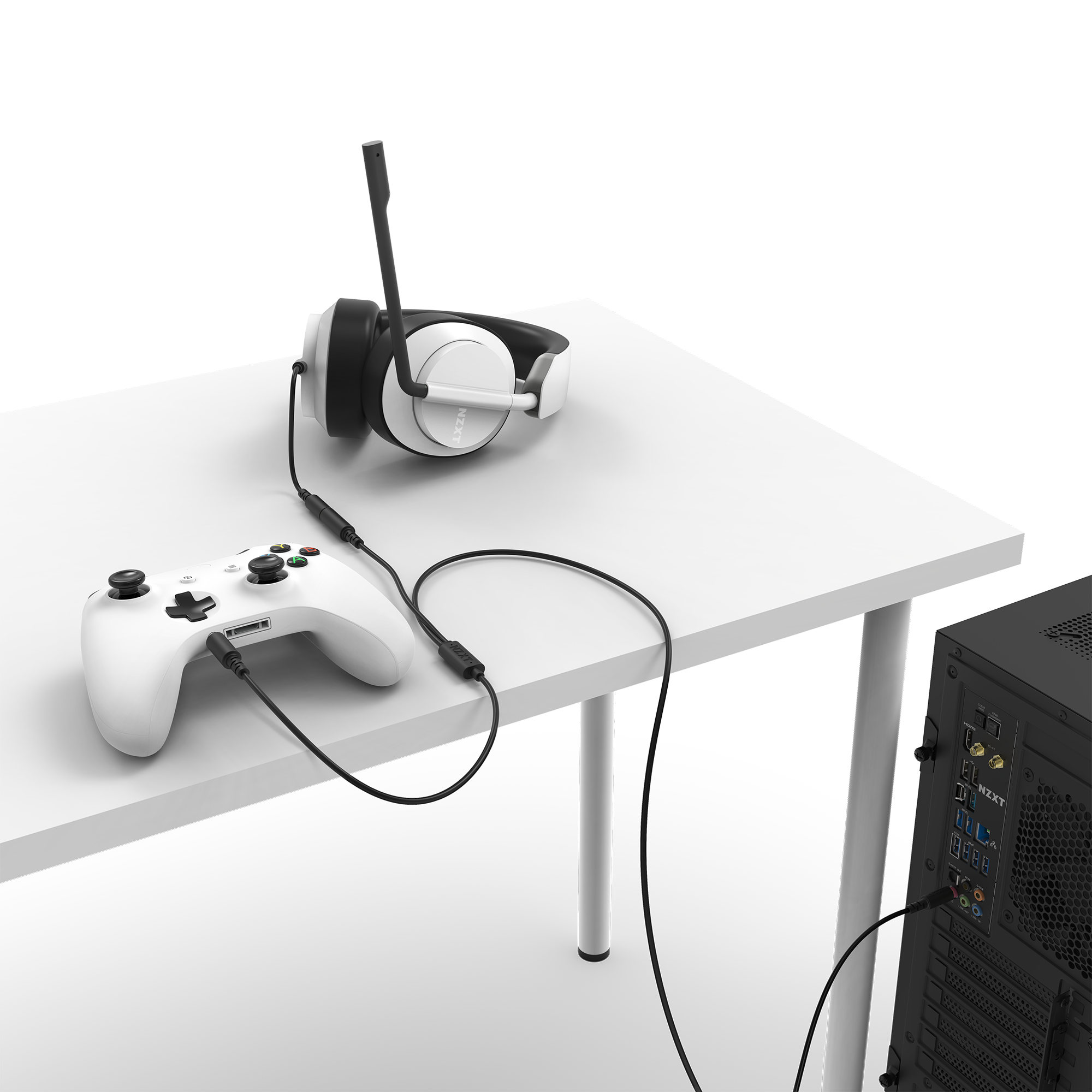 The NZXT Chat Cable connects a white gaming controller to a white headset on a white desk beside a black computer tower, delivering seamless party chat audio with an easy plug-and-play setup.