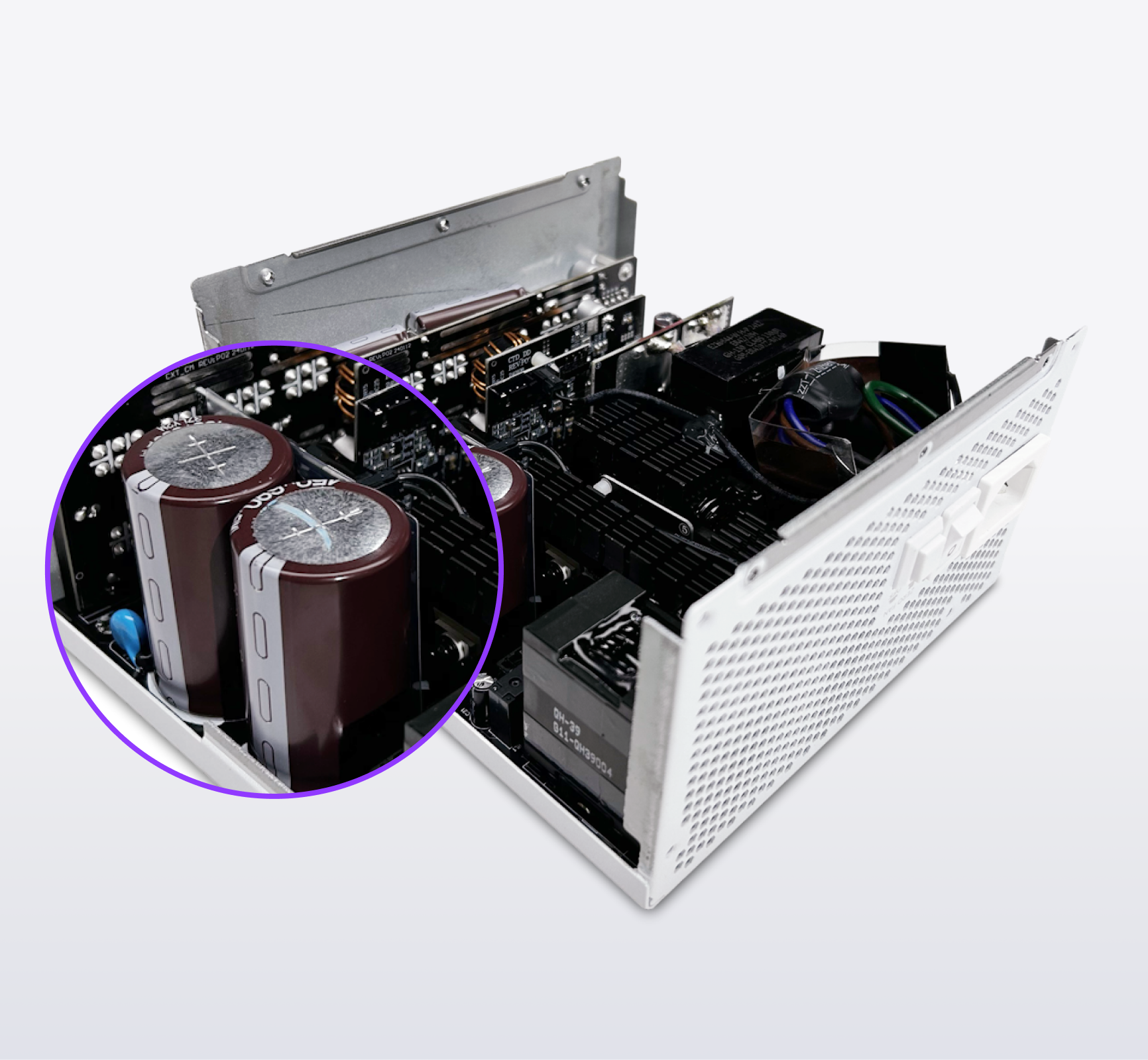 A close-up view of an open white electronic device casing, revealing internal components and circuitry, with a purple circle highlighting two large cylindrical capacitors.