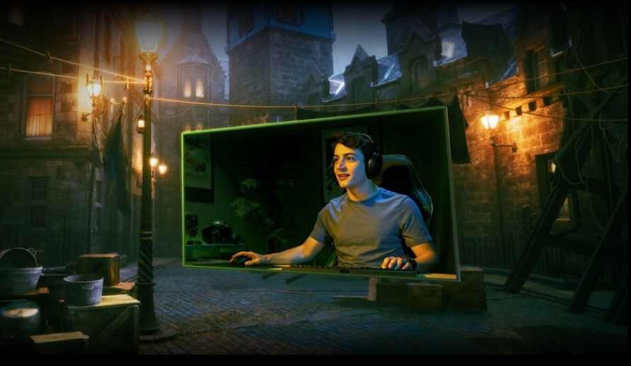 A young man wearing headphones and gaming at a computer is framed by a green border, superimposed on a dimly lit, old-fashioned street scene with cobblestones, street lamps, and brick buildings.