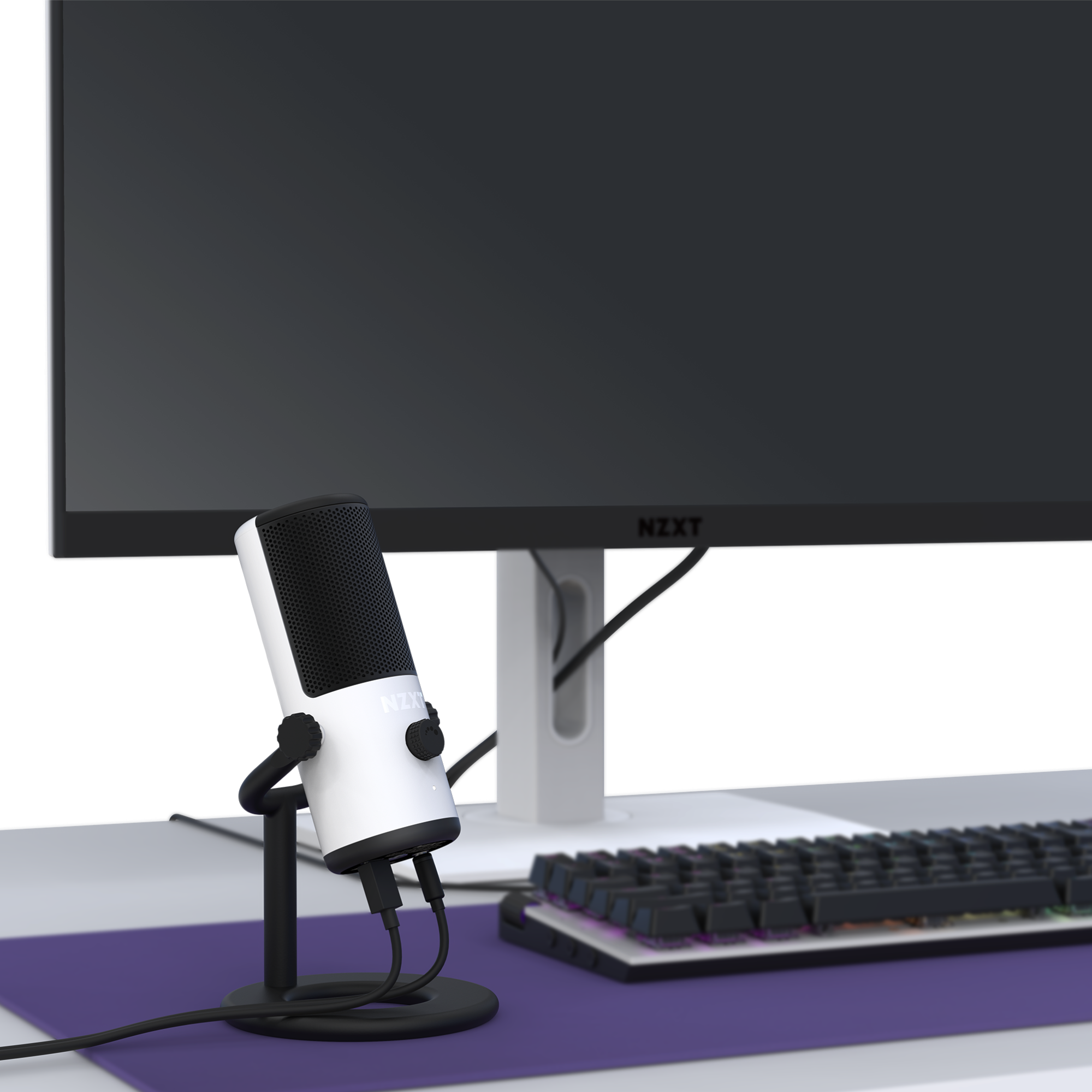 A desktop setup with a large monitor, an RGB mechanical keyboard, and the NZXT Capsule Mini USB microphone (white) on a stand rests atop a purple desk mat—ideal for content creation or game streaming.